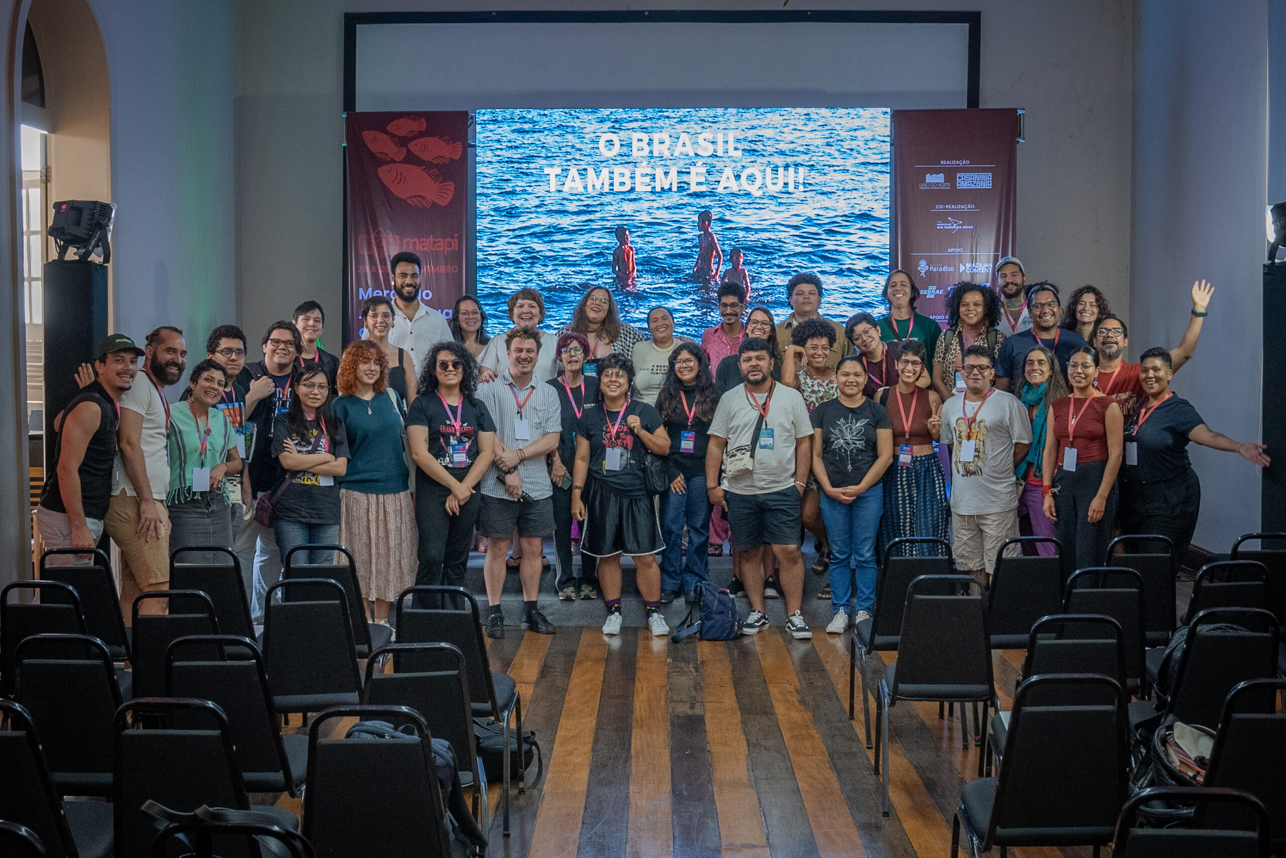 Grupo de participantes do Matapi 2019 posando juntos diante de um banner do evento